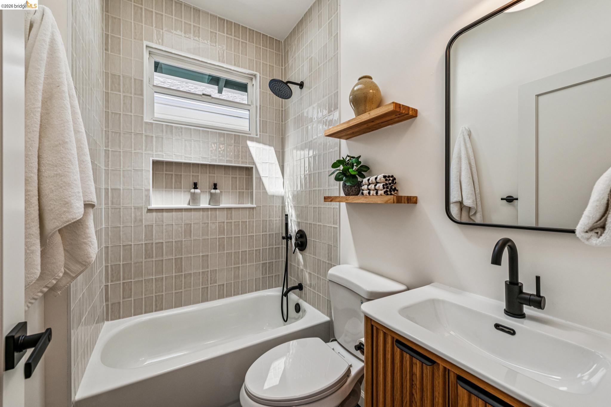 6521 Dover Street Berkeley, CA 94703 - Photo 25 of 80 Bathroom featuring a tiled shower/tub combination with a recessed niche, a window, and matte black fixtures