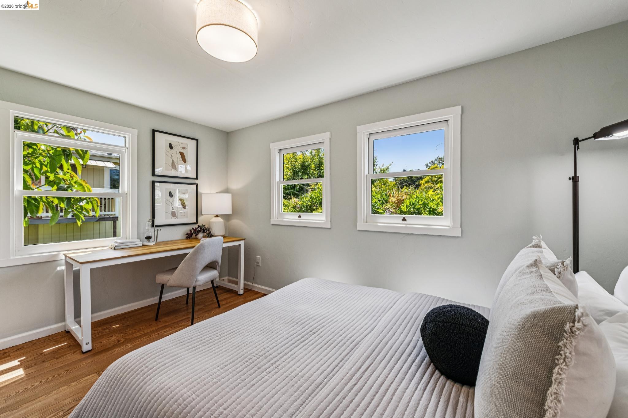 6521 Dover Street Berkeley, CA 94703 - Photo 32 of 80 Room featuring wood-finish flooring, light gray wall paint, and multiple white-framed windows
