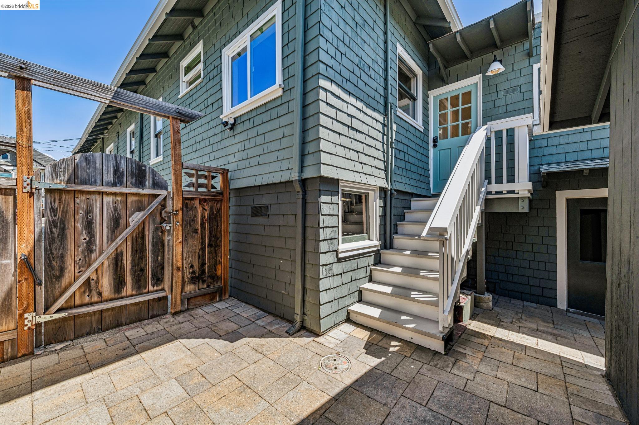 6521 Dover Street Berkeley, CA 94703 - Photo 34 of 80 Patio area featuring paver flooring, a wooden gate, and exterior stairs with white railings