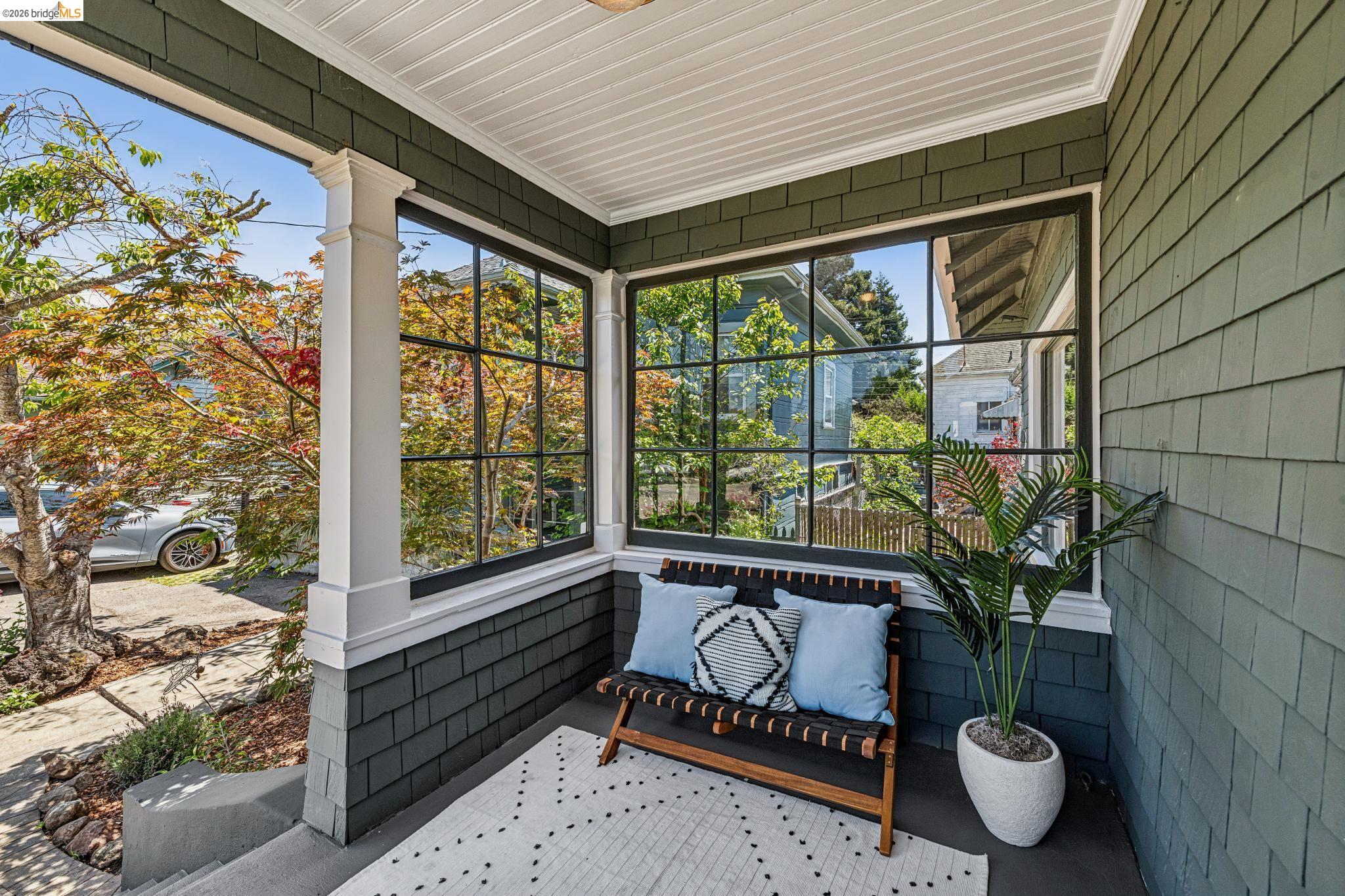 6521 Dover Street Berkeley, CA 94703 - Photo 4 of 80 Covered porch with shingle siding, large multi-pane windows, white trim, and a beadboard ceiling