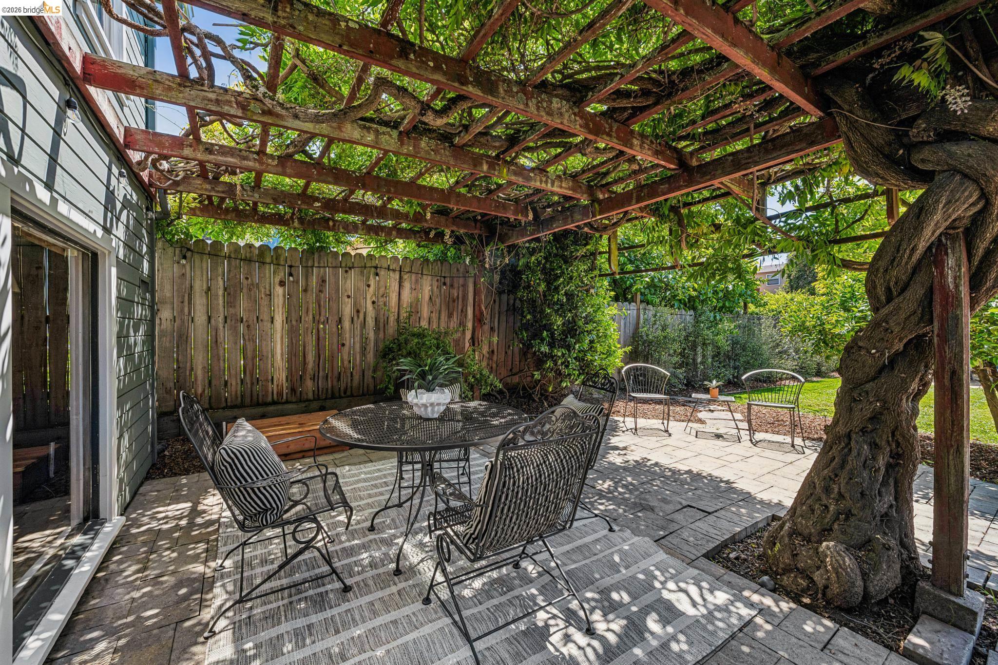6521 Dover Street Berkeley, CA 94703 - Photo 46 of 80 Patio area featuring a mature vine-covered pergola, paver flooring, horizontal siding exterior, and a wood privacy fence