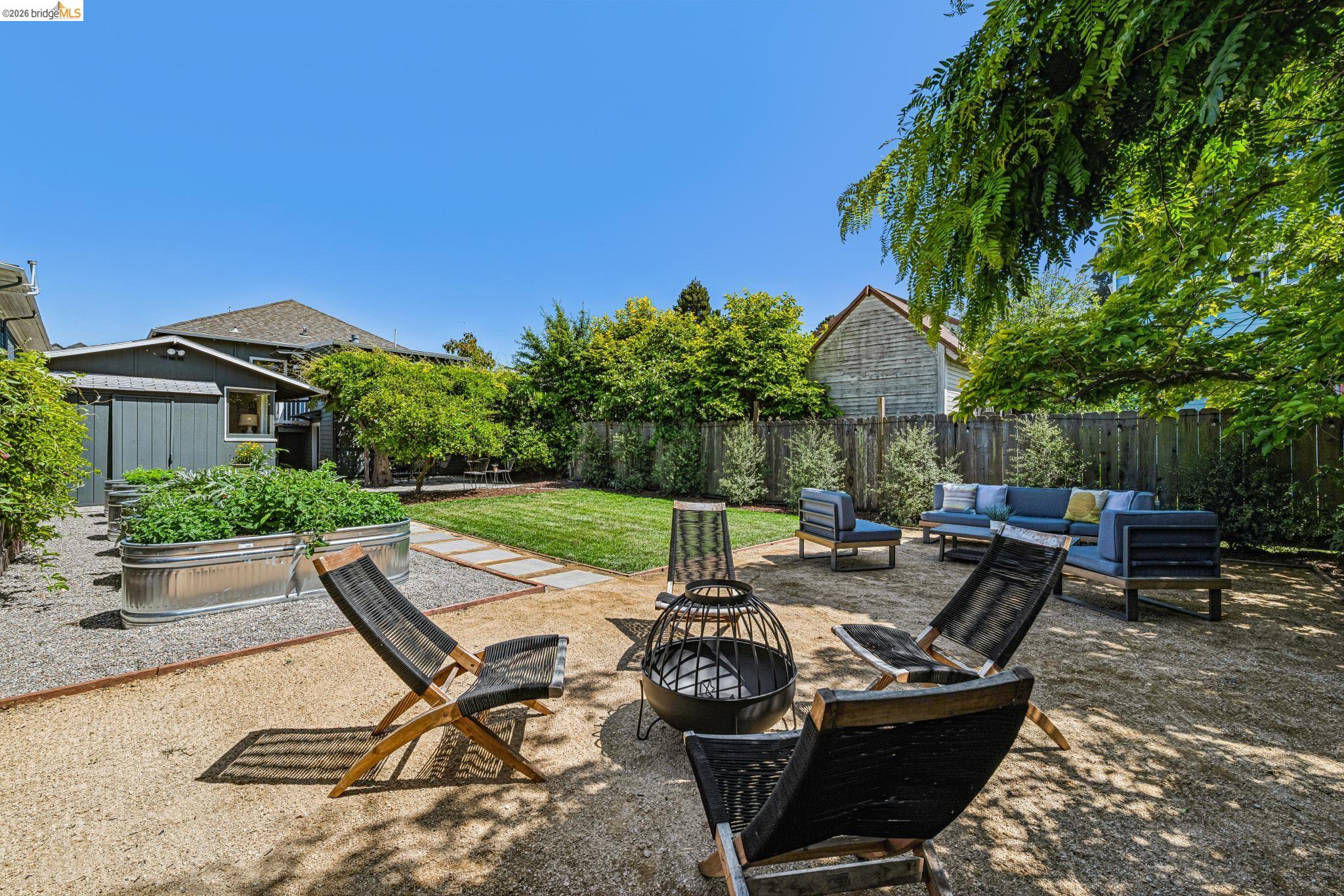 6521 Dover Street Berkeley, CA 94703 - Photo 58 of 80 Spacious backyard featuring a gravel patio, manicured lawn area, a privacy fence, a detached shed, and raised garden beds