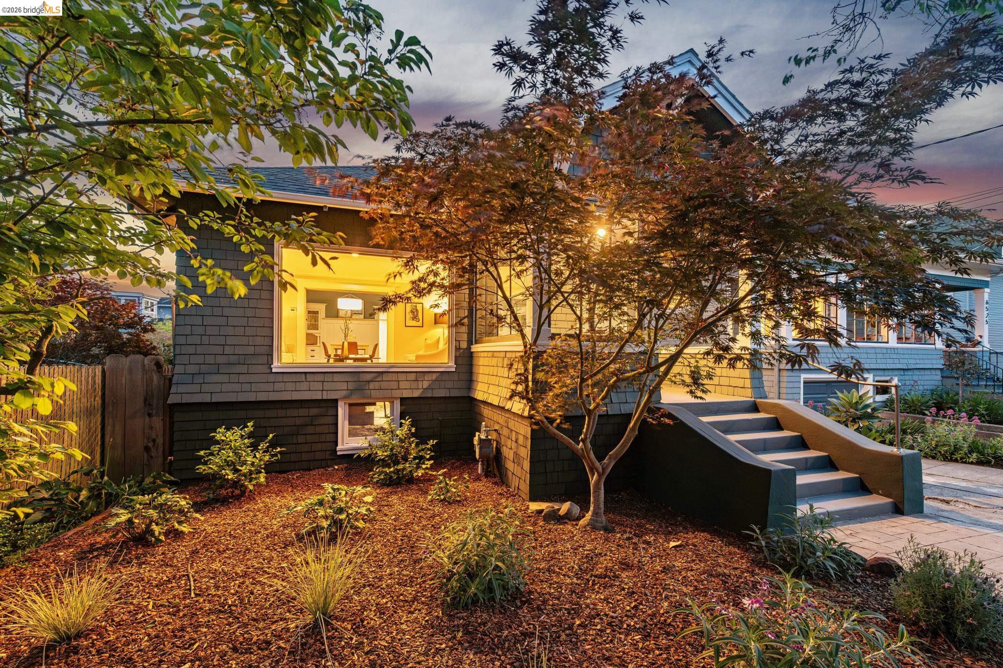 6521 Dover Street Berkeley, CA 94703 - Photo 60 of 80 Exterior featuring gray shingle siding, a prominent picture window, and a landscaped front yard with a mature tree