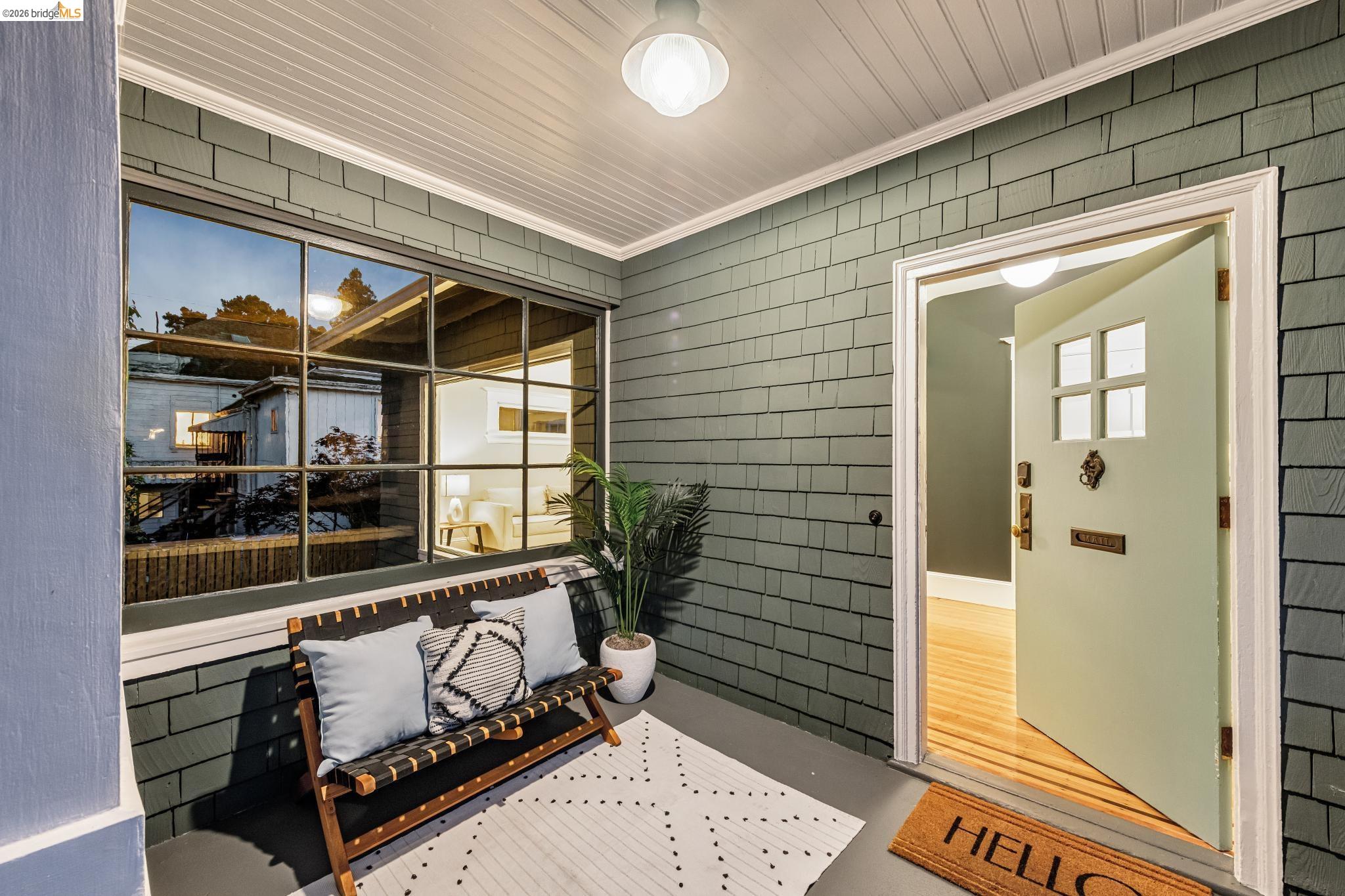 6521 Dover Street Berkeley, CA 94703 - Photo 62 of 80 Inviting front porch featuring shake siding, a large multi-pane window, and a light-colored entry door with decorative hardware