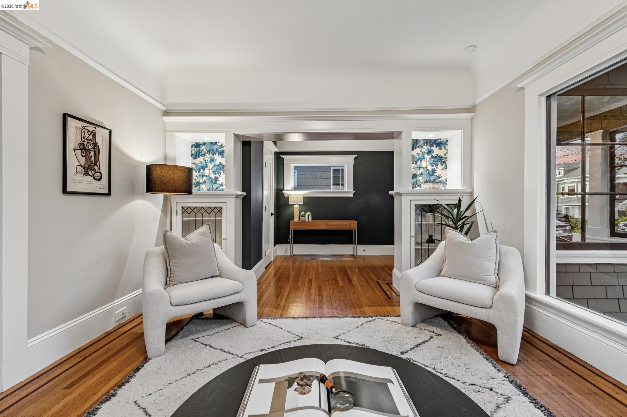 6521 Dover Street Berkeley, CA 94703 - Photo 63 of 80 Living area featuring rich wood-finish flooring, white trim detailing, and built-in shelving with decorative grilles