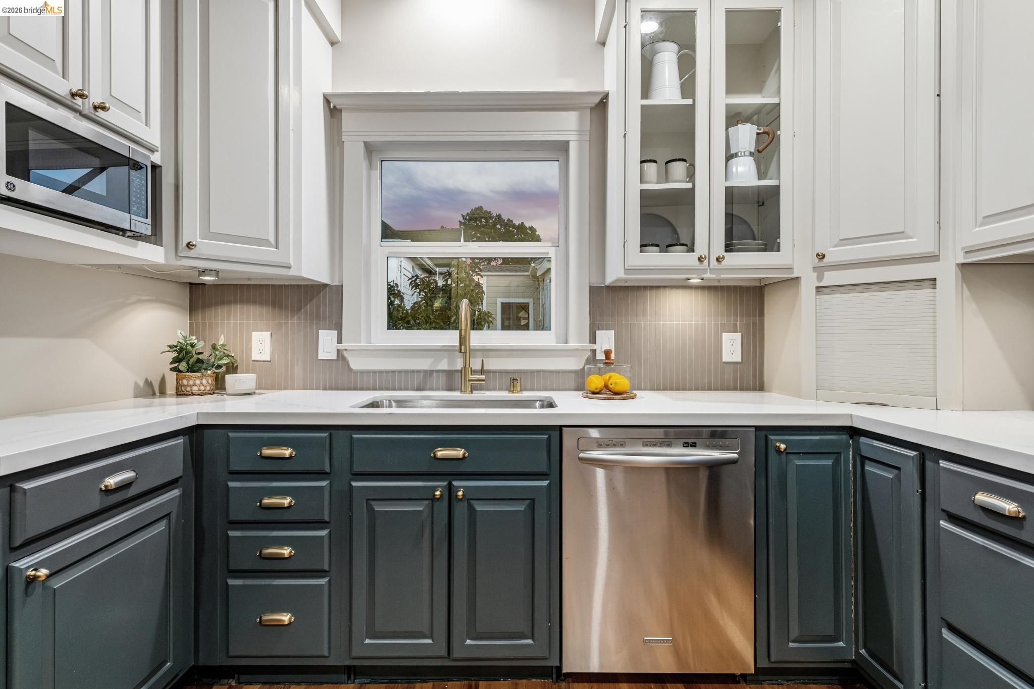 6521 Dover Street Berkeley, CA 94703 - Photo 64 of 80 Kitchen featuring white upper cabinetry, dark lower cabinetry, stainless steel appliances, and a tiled backsplash
