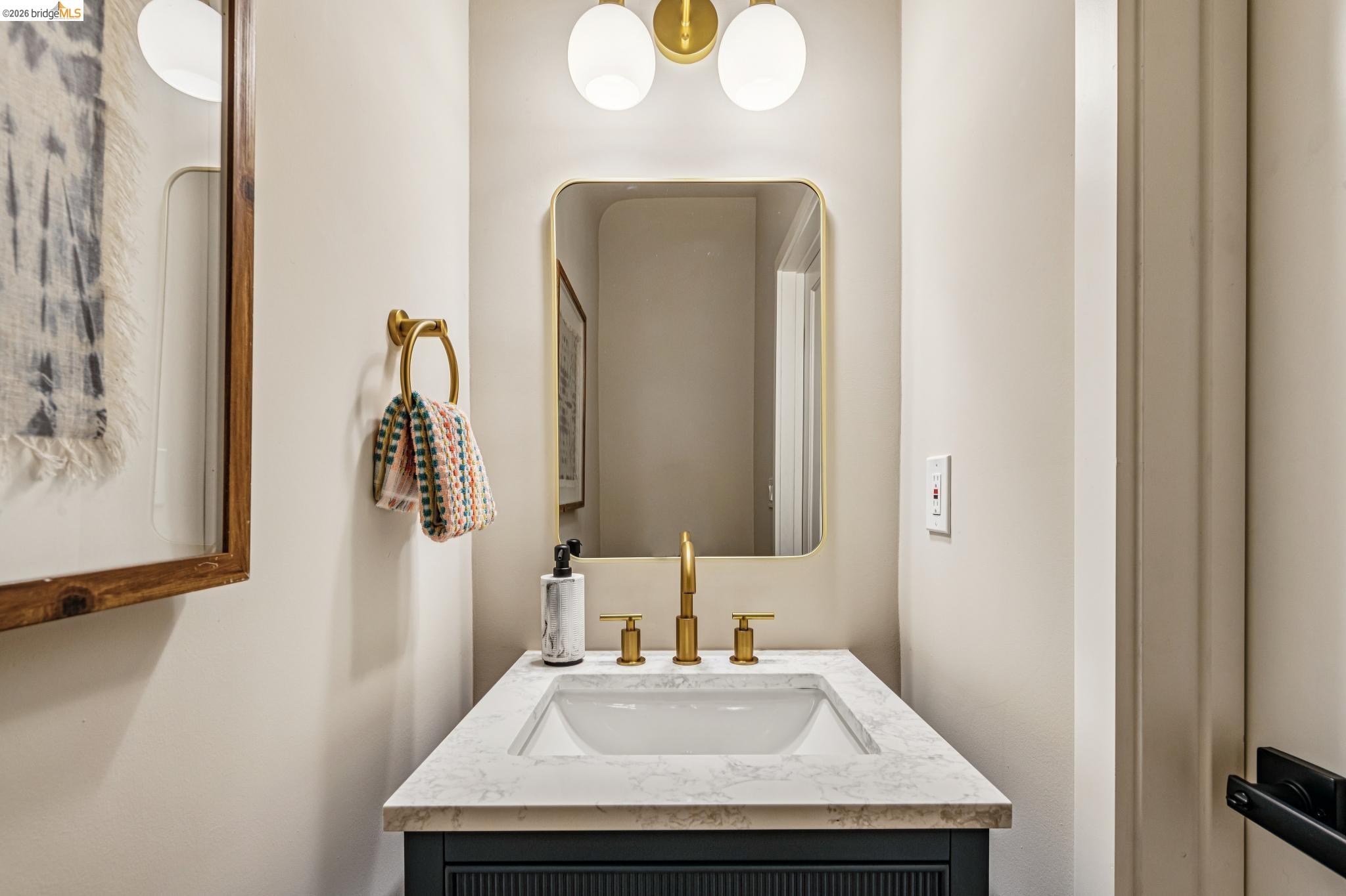 6521 Dover Street Berkeley, CA 94703 - Photo 7 of 80 Vanity with a white composite countertop and integrated sink, featuring a brass-finish faucet set