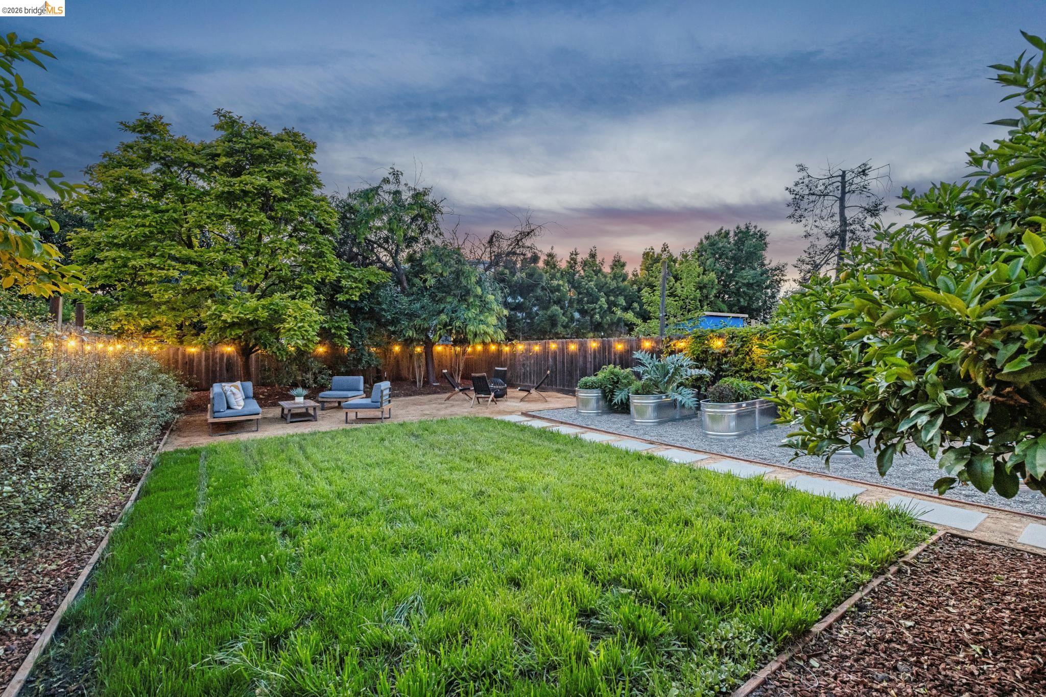 6521 Dover Street Berkeley, CA 94703 - Photo 76 of 80 Expansive backyard featuring a central lawn area, gravel paths, and raised metal planters