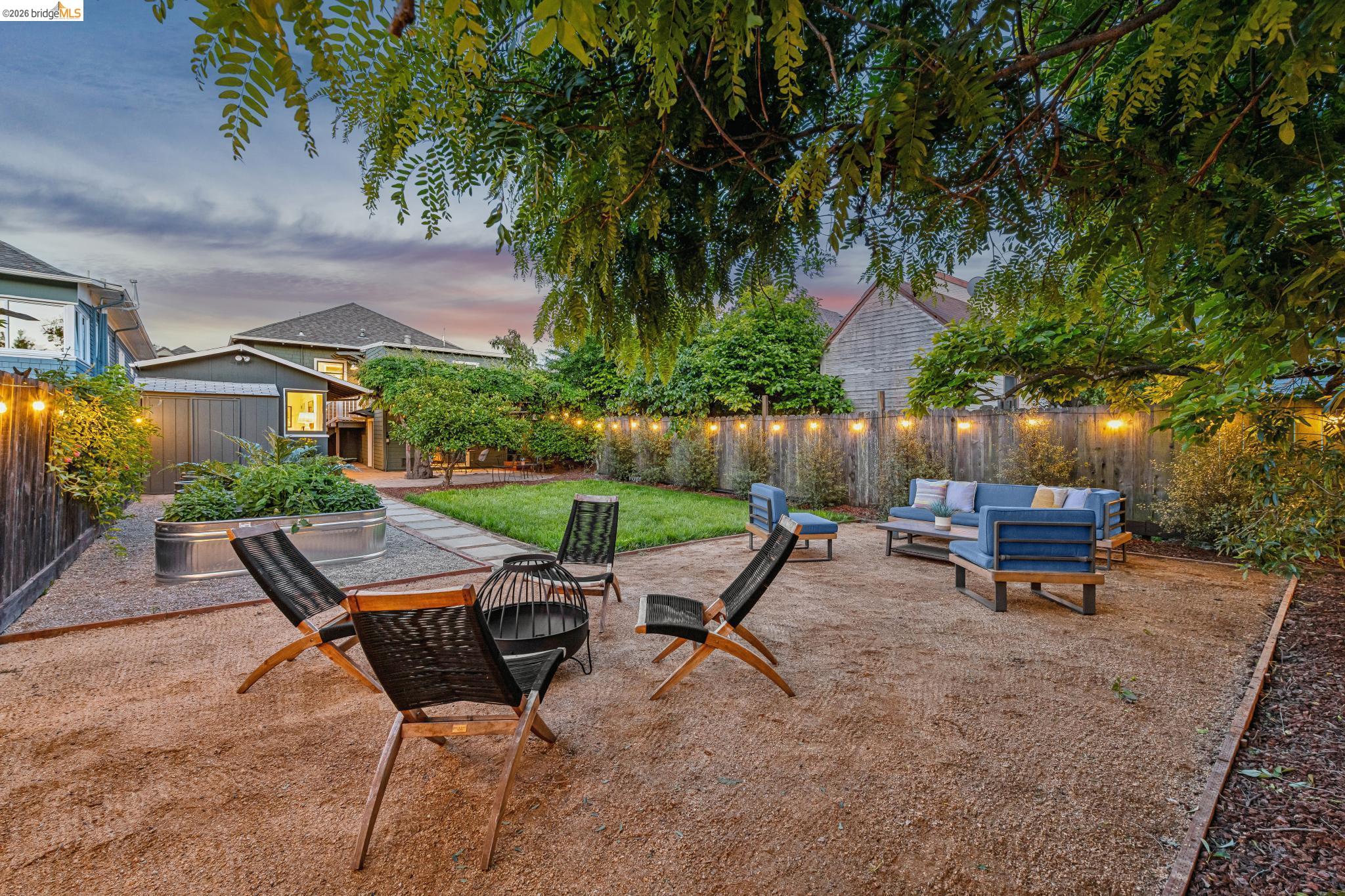 6521 Dover Street Berkeley, CA 94703 - Photo 78 of 80 Spacious backyard featuring a large gravel patio area, a manicured lawn, and a raised metal planter