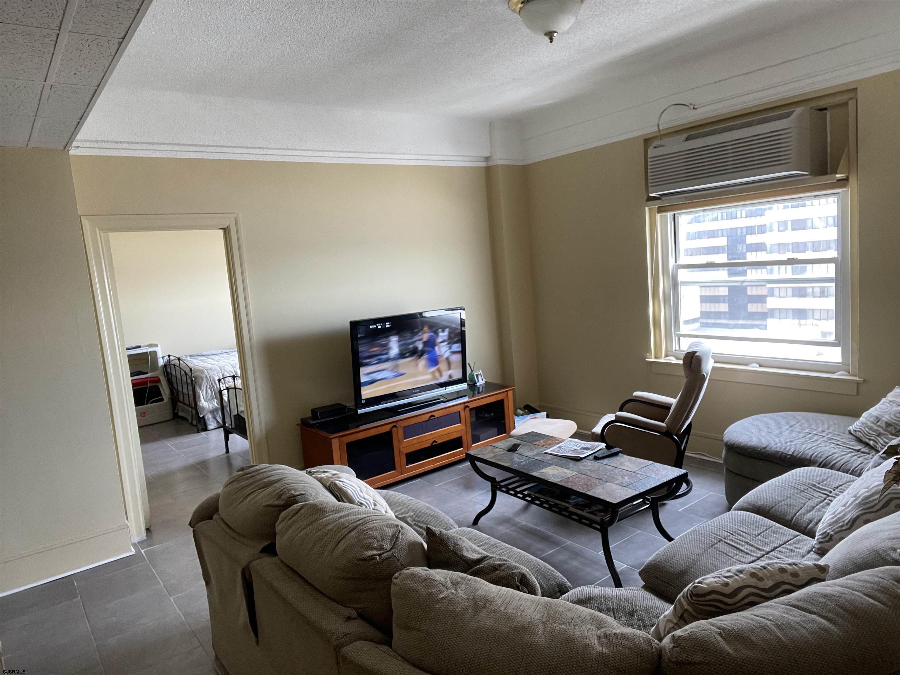 2715 Boardwalk, Unit 1209 Atlantic City, NJ 08401 - Photo 12 of 57 a living room with furniture a flat screen tv and a window