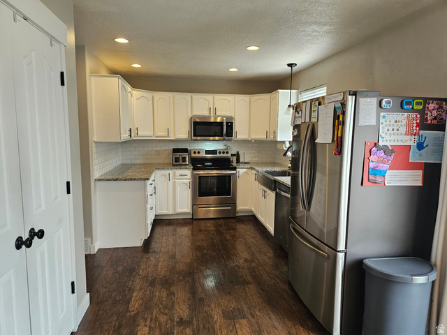 7481 Red Pine Road Eagle Mountain, UT 84005 - Photo 5 of 38 Kitchen featuring white cabinetry, stainless steel appliances, speckled countertops, and wood-finish flooring