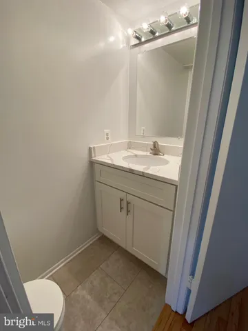 a bathroom with a granite countertop sink a toilet and a mirror