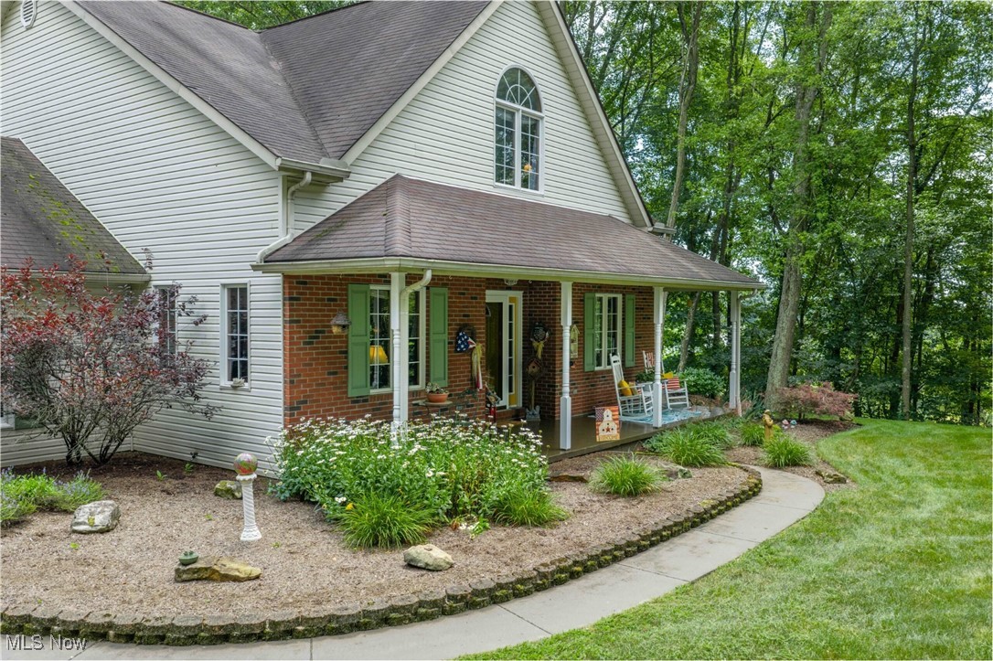 6535 Middle Run Road Dover, OH 44622 - Photo 28 of 40 View of front of house with covered porch, a shingled roof, brick siding, and a front yard