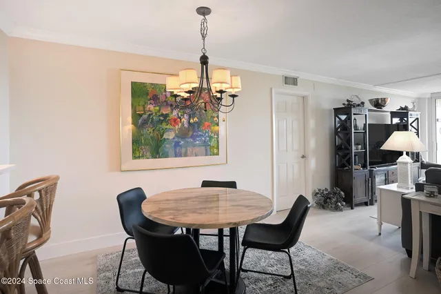 a view of a dining room with furniture and a chandelier