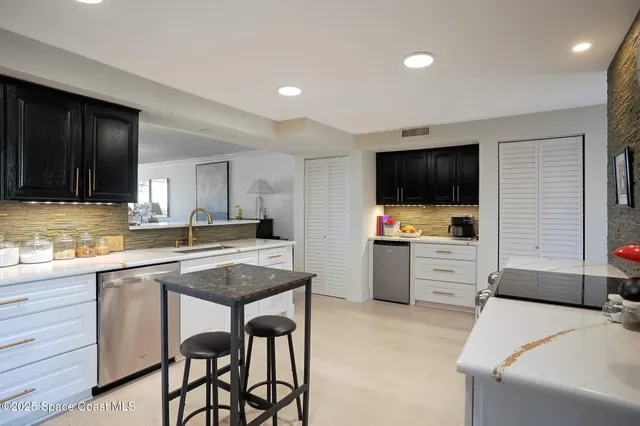 a kitchen with appliances a sink and cabinets