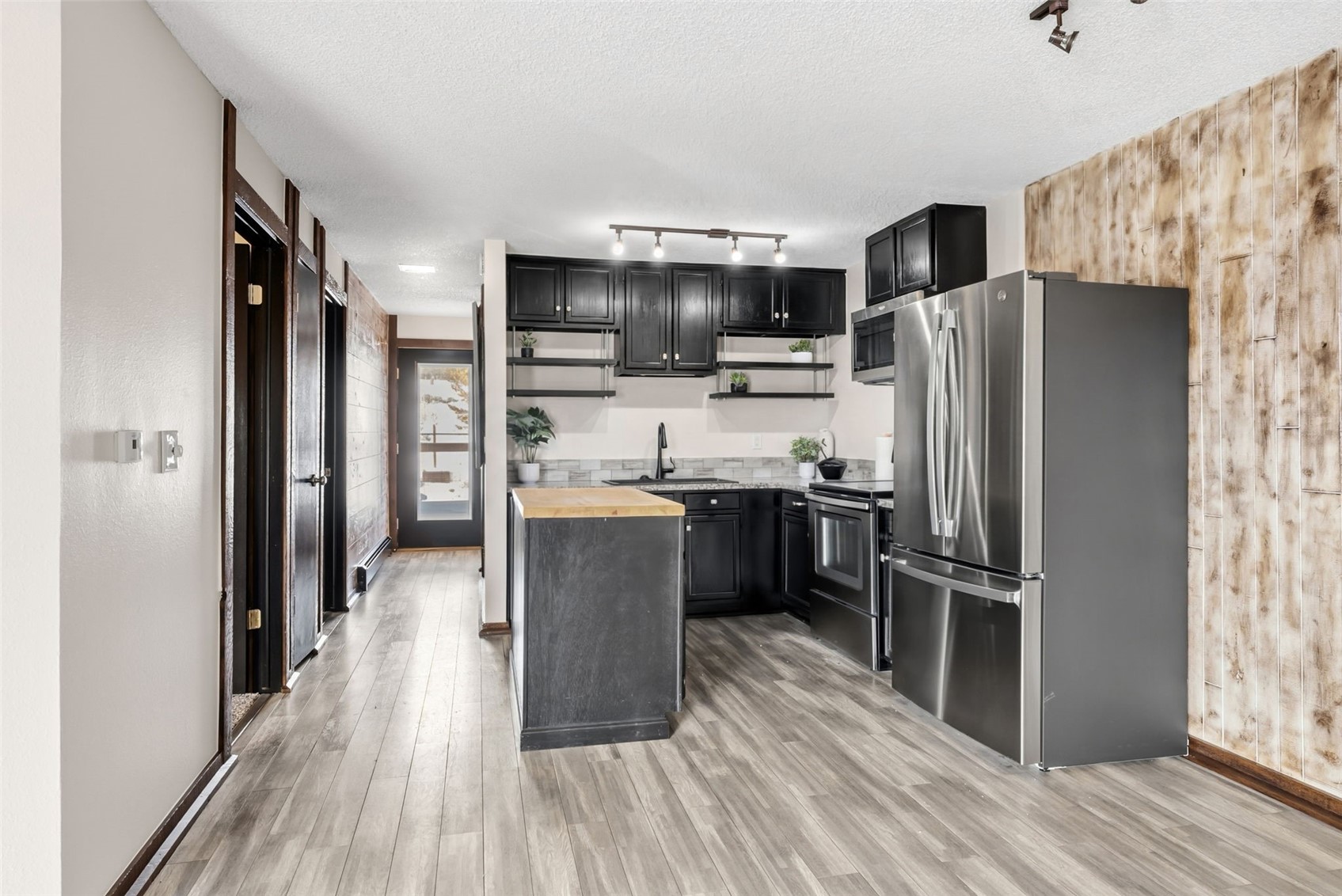 7124 Ryan Gulch Road, Unit 204 Wildernest, CO 80498 - Photo 17 of 36 Kitchen featuring dark cabinets, wooden counters, stainless steel appliances, open shelves, and wood walls