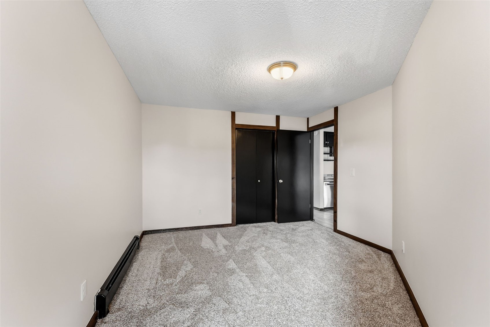 7124 Ryan Gulch Road, Unit 204 Wildernest, CO 80498 - Photo 26 of 36 Unfurnished bedroom featuring a textured ceiling, a baseboard heating unit, carpet, and a closet