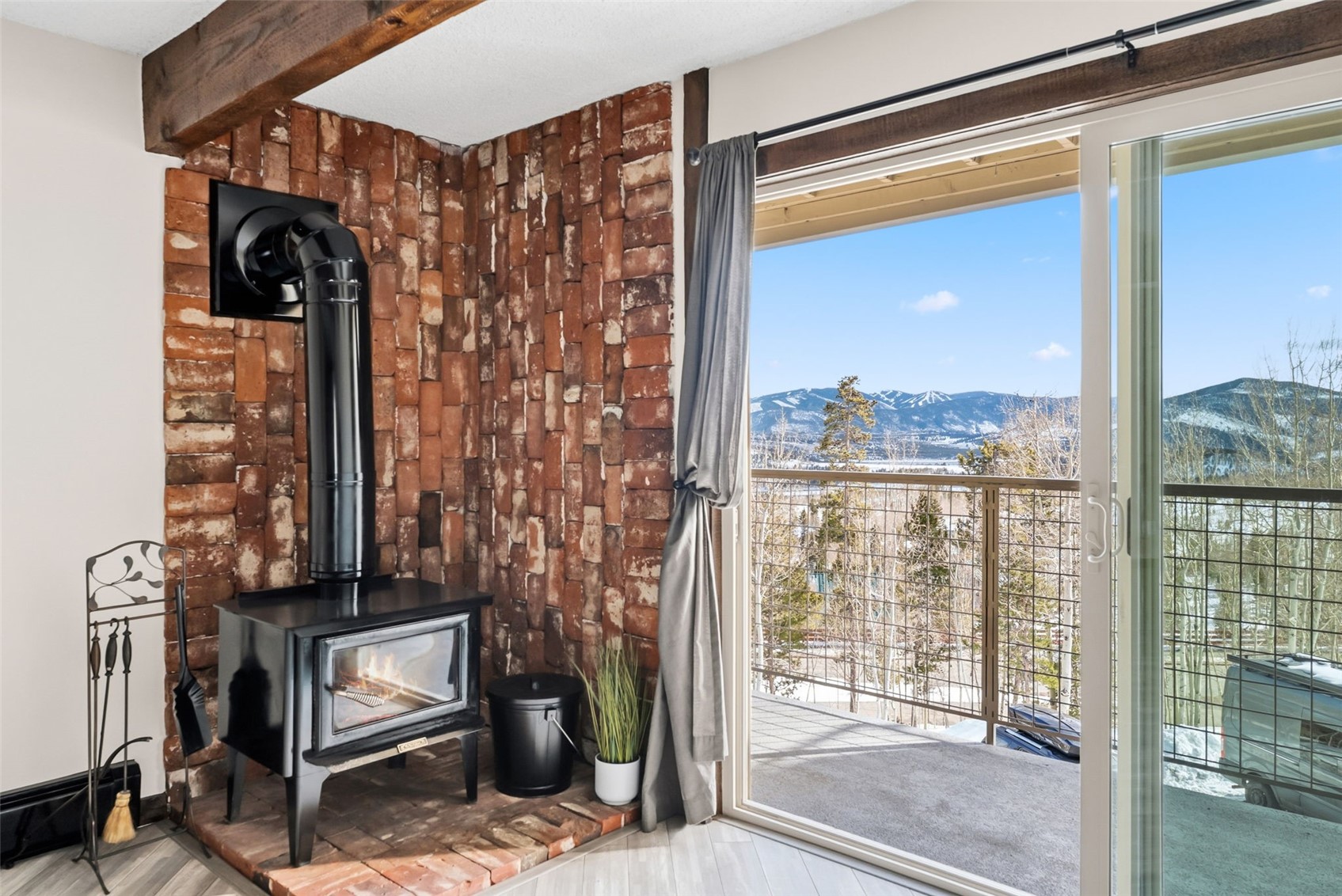 7124 Ryan Gulch Road, Unit 204 Wildernest, CO 80498 - Photo 5 of 36 Detailed view of a wood stove, a mountain backdrop, and wood finished floors