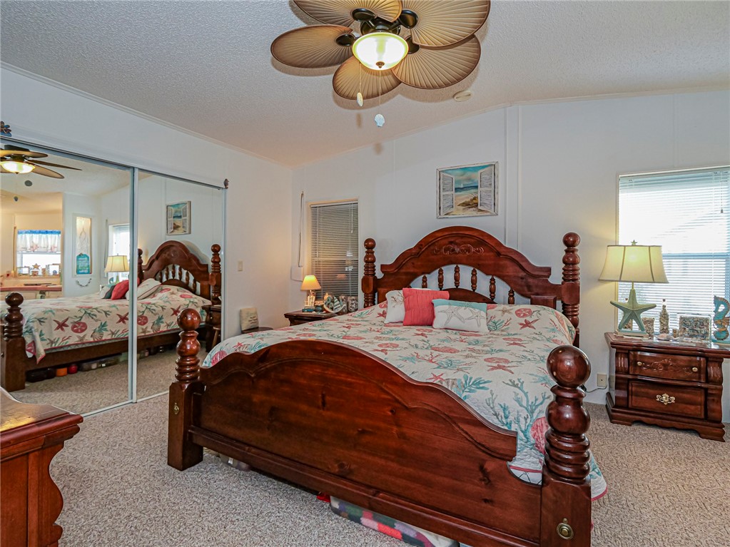 7648 Kyak Court, Unit Q16 Sebastian, FL 32976 - Photo 13 of 34 a bedroom with a bed and a chandelier