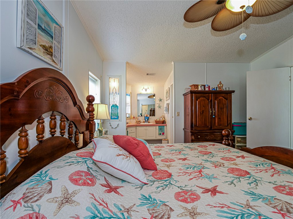 7648 Kyak Court, Unit Q16 Sebastian, FL 32976 - Photo 16 of 34 a bedroom with a bed and a painting on the wall
