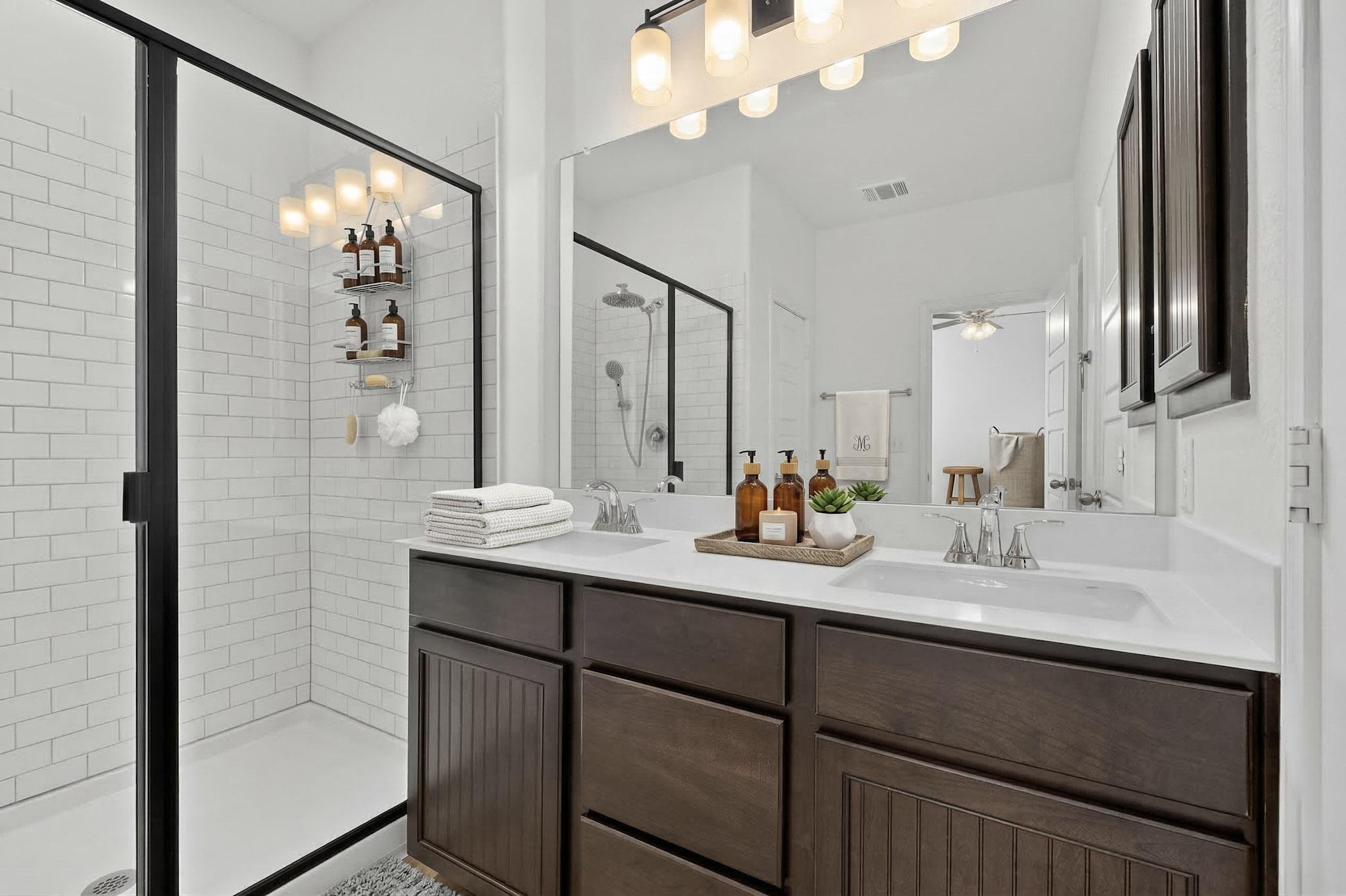 14513 Booted Eagle Pass Elgin, TX 78621 - Photo 20 of 33 En suite bath with a dual-sink vanity, dark cabinetry, and ample counter space for everyday convenience.