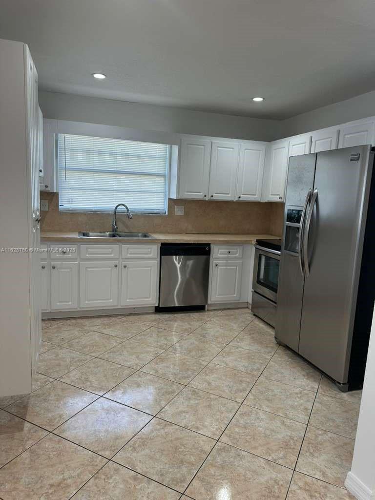 208 Southwest 2nd Avenue Hallandale Beach, FL 33009 - Photo 4 of 21 a kitchen with granite countertop a stove a sink and a refrigerator