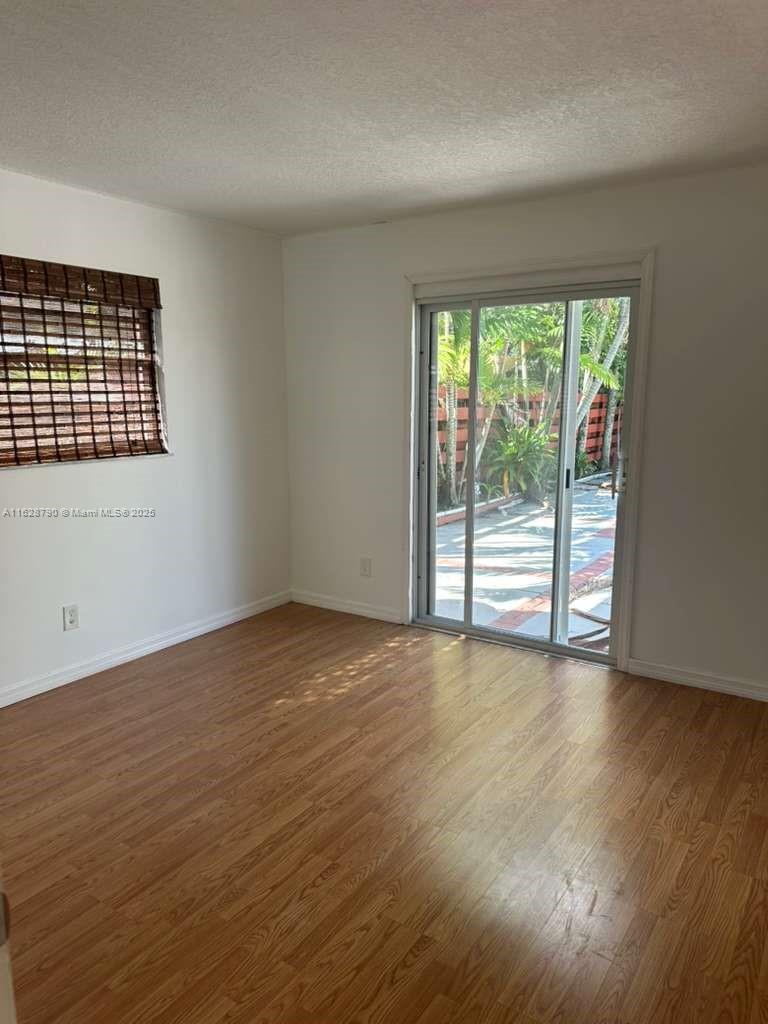 208 Southwest 2nd Avenue Hallandale Beach, FL 33009 - Photo 9 of 21 a view of an empty room with wooden floor and a window