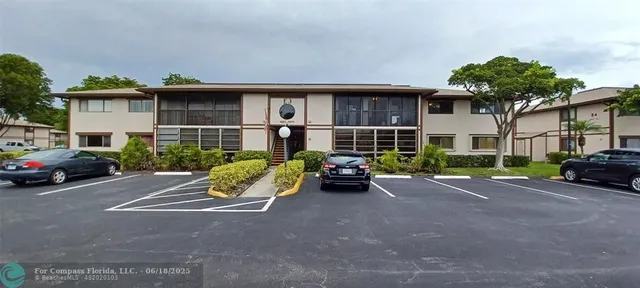 a view of a street with a couple of cars parked in front of a house