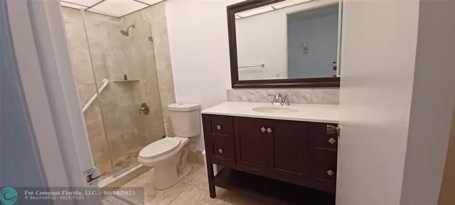 a bathroom with a sink vanity mirror and toilet