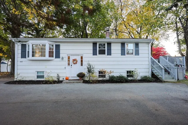 a view of a house with a backyard and a tree