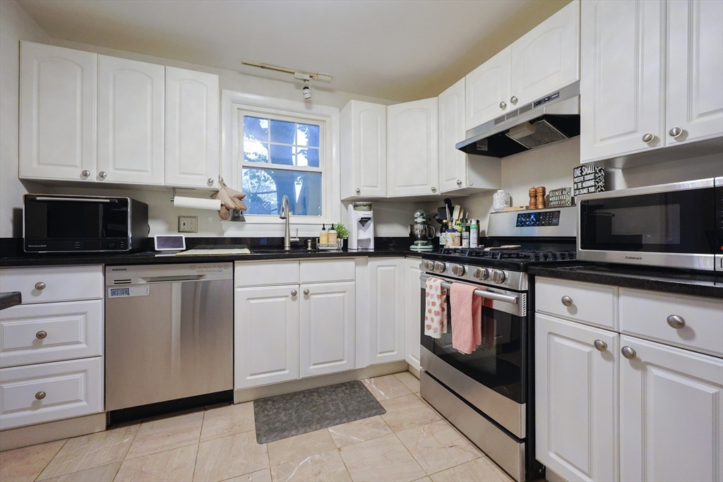 182 Summer Street Framingham, MA 01701 - Photo 6 of 30 a kitchen with stainless steel appliances granite countertop a stove a sink and a microwave