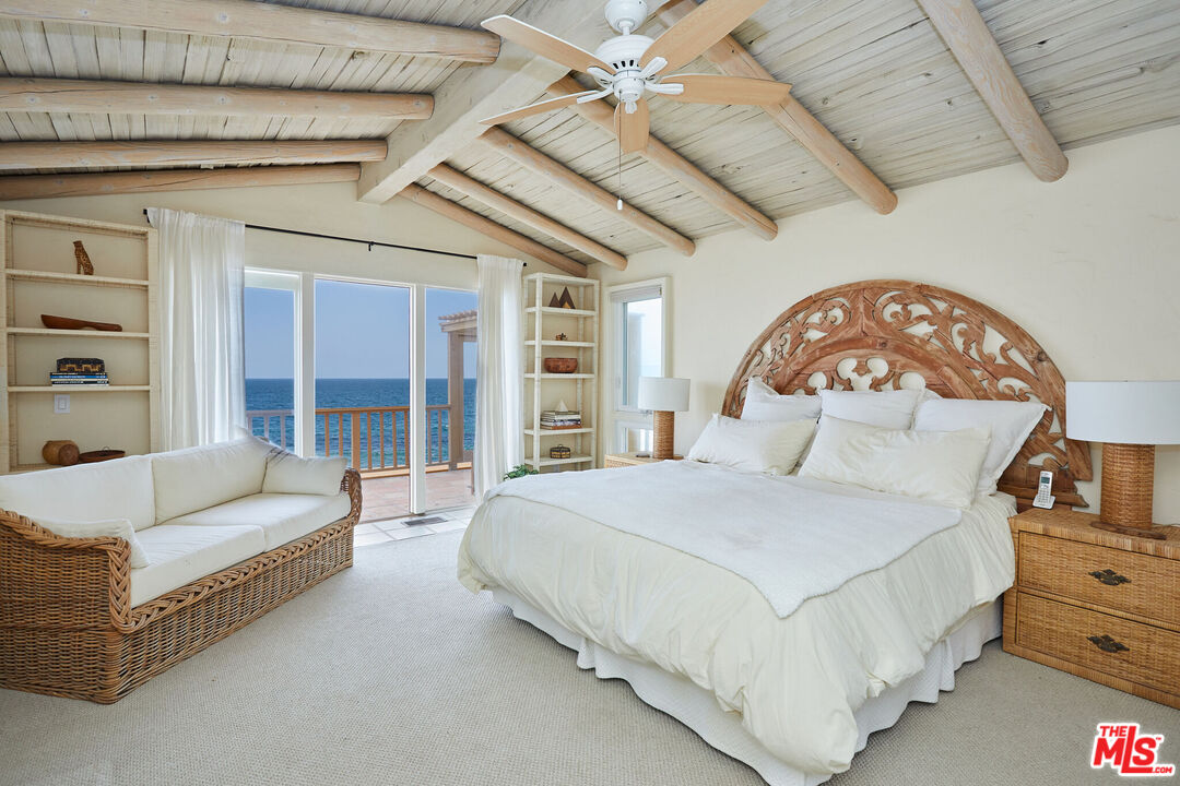 25110 Malibu Road Malibu, CA 90265 - Photo 15 of 28 a spacious bedroom with a bed couch and a large window