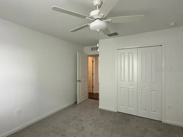 an empty room with a window and a fan