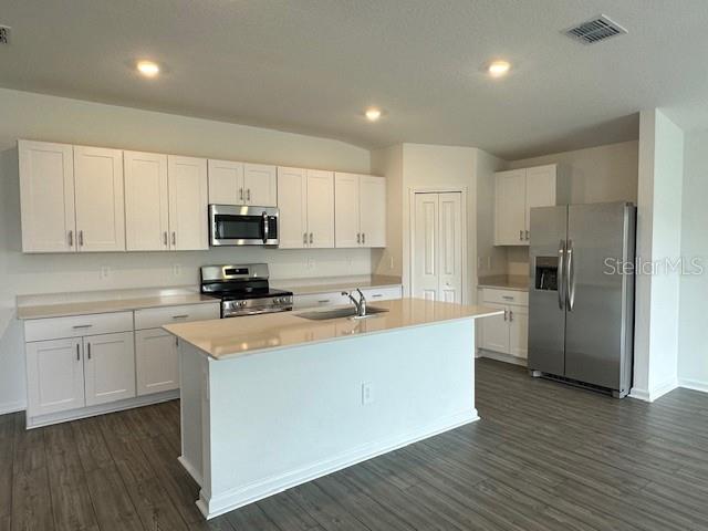 4534 Southwest 84th St Road Ocala, FL 34476 - Photo 24 of 31 a kitchen with stainless steel appliances granite countertop a refrigerator a sink dishwasher a stove top oven a refrigerator with white cabinets and wooden floor