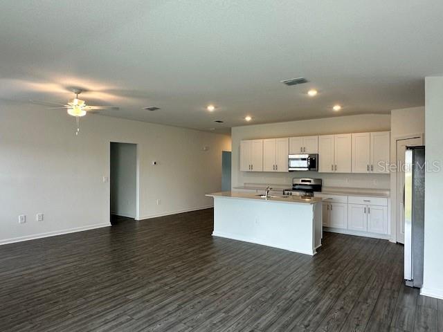 4534 Southwest 84th St Road Ocala, FL 34476 - Photo 25 of 31 a kitchen with stainless steel appliances kitchen island wooden floors and white cabinets
