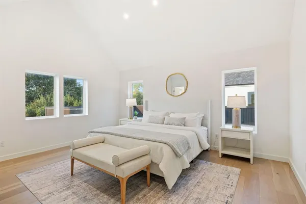 a bedroom with a bed a mirror and a window