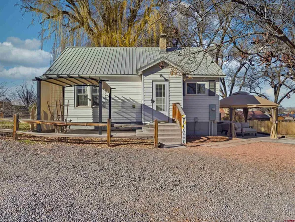 a view of a house with a yard and wooden fence
