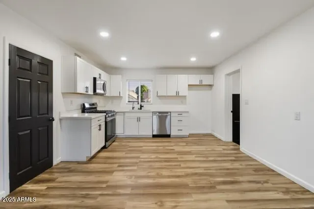 a kitchen with stainless steel appliances granite countertop a refrigerator sink and cabinets