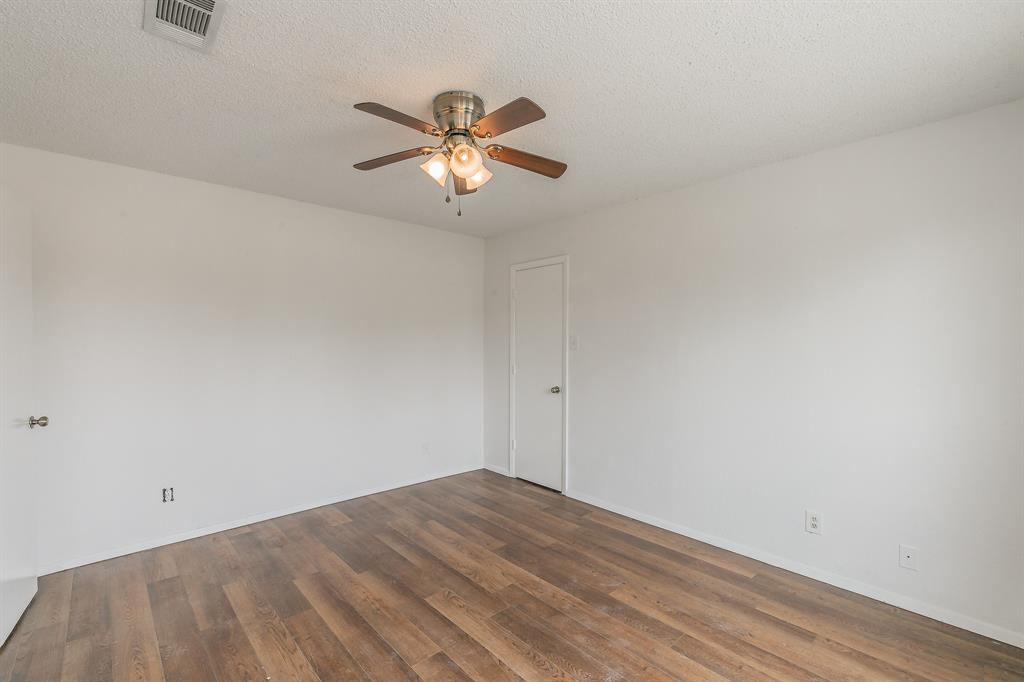 920 Turtle Cove, Unit 252 Irving, TX 75060 - Photo 17 of 34 Unfurnished room with a ceiling fan, wood finished floors, baseboards, and a textured ceiling