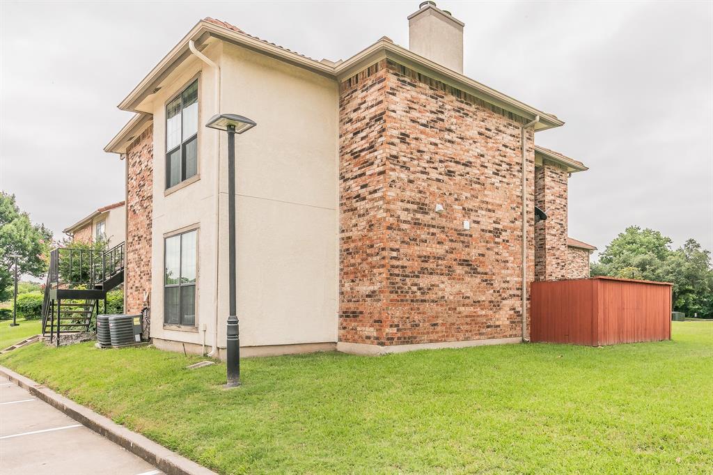 920 Turtle Cove, Unit 252 Irving, TX 75060 - Photo 33 of 34 View of home's exterior featuring stairway, a chimney, central AC unit, and a lawn