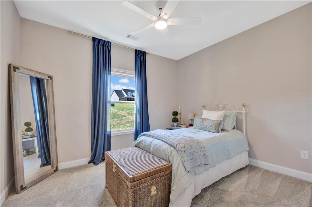 90 Scouts Ridge Drive Covington, GA 30016 - Photo 17 of 21 a bedroom with a bed and a chandelier