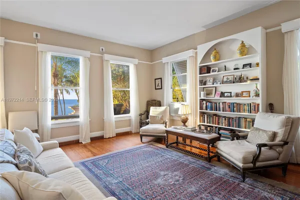 a living room with furniture and floor to ceiling windows
