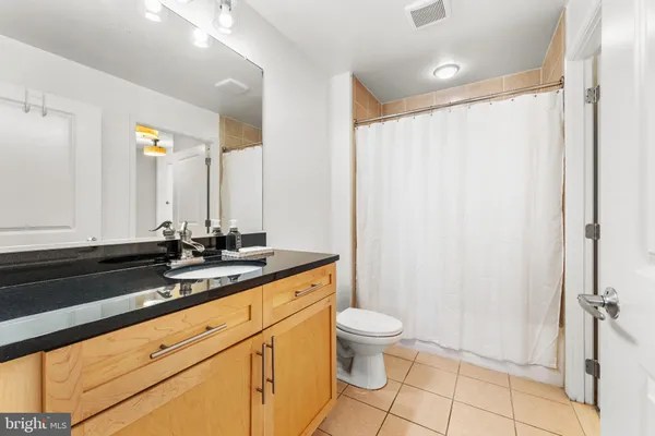 a bathroom with a granite countertop sink toilet and shower