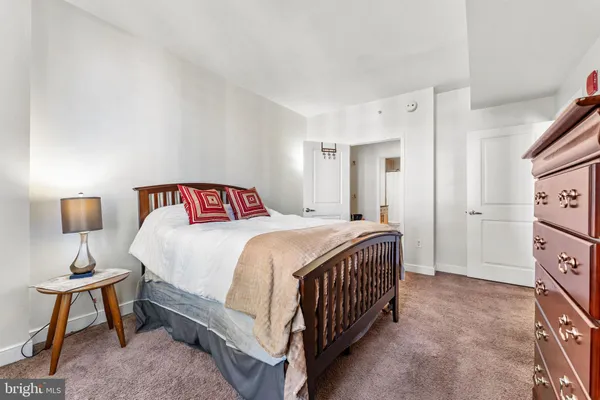 a bedroom with a bed a mirror and lamp