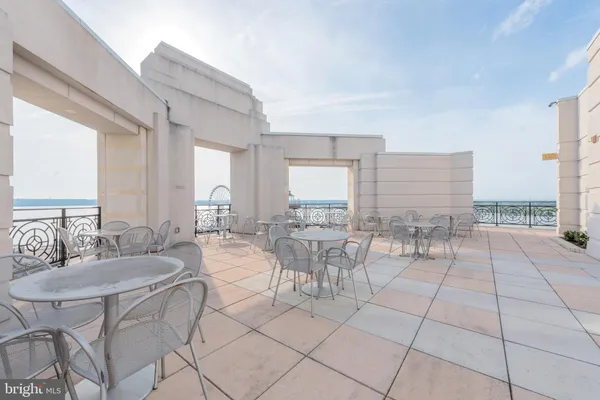 a room with lots of white furniture and large windows