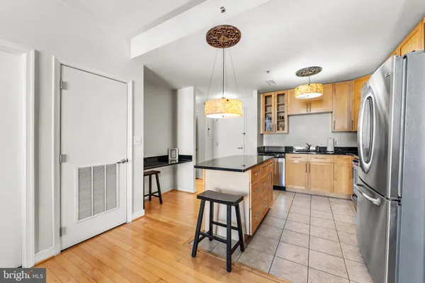 a large kitchen with a table chairs refrigerator and cabinets