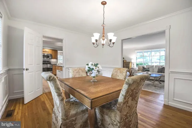 a view of a dining room with furniture a chandelier and wooden floor
