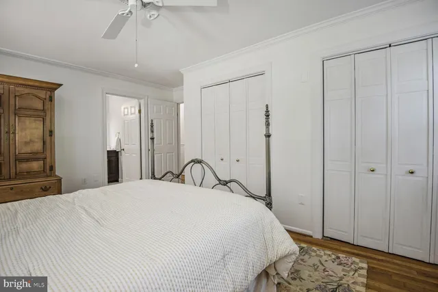 a bathroom with a toilet a sink a mirror a window and vanity