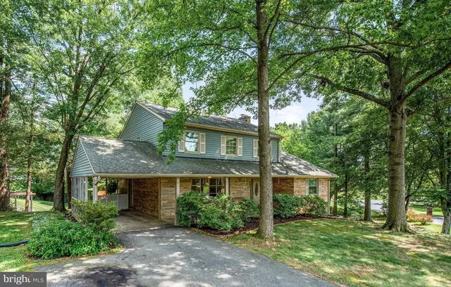 a view of a house with a yard garage and tree