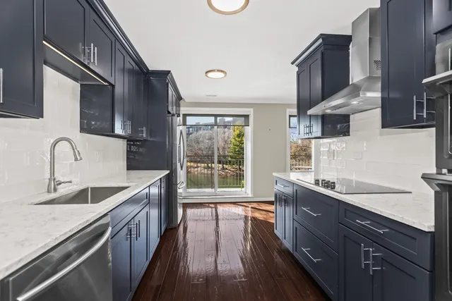 a kitchen with granite countertop a sink a counter space appliances and cabinets